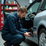 Technicien automobile déconnectant le module BSI sous le tableau de bord d'une Peugeot 307 HDI dans un garage